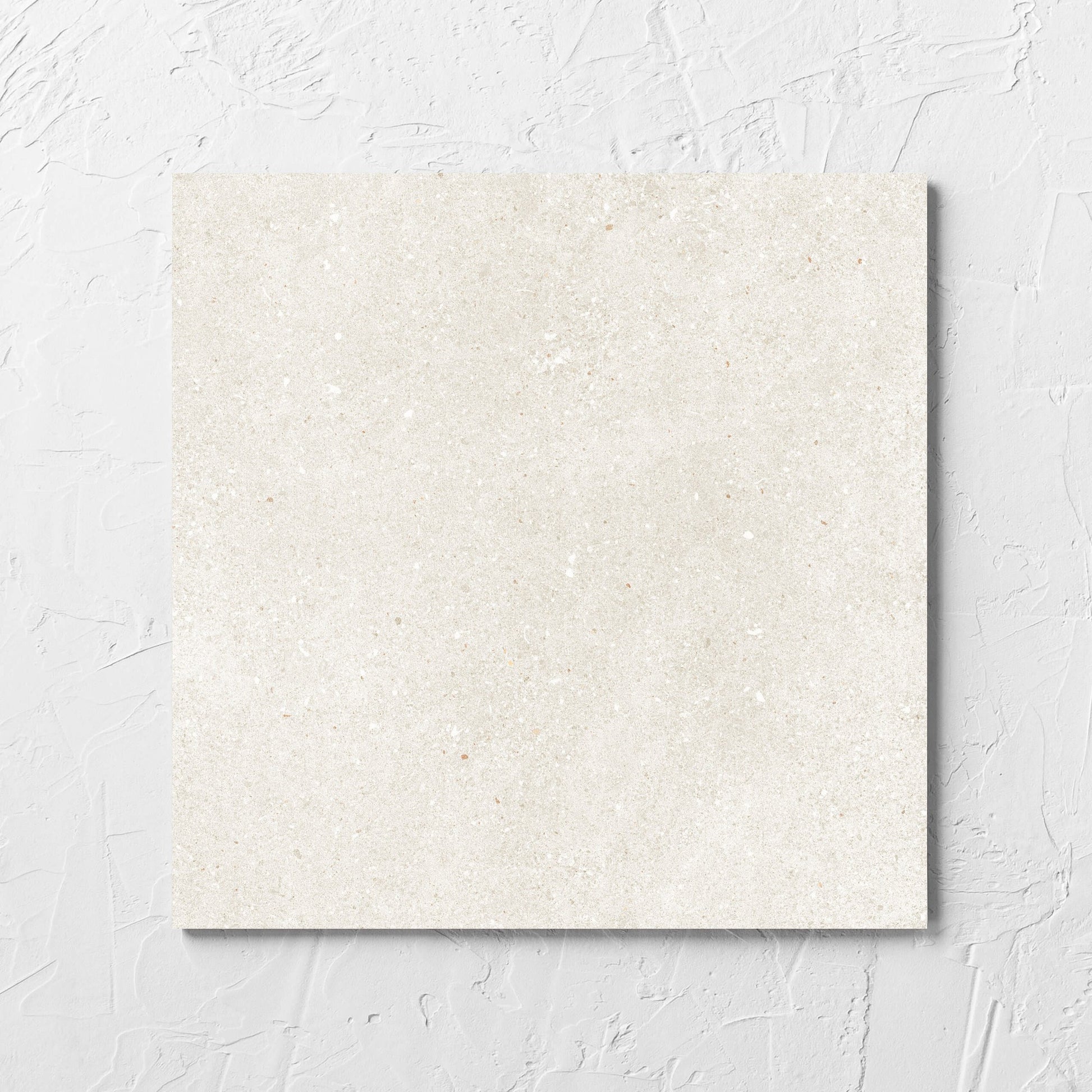 Serenity Beach Sand 300x300mm tile laid flat on a white rendered wall, showing the matt surface