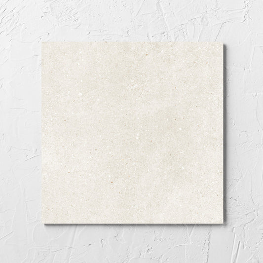 Serenity Beach Sand 300x300mm tile laid flat on a white rendered wall, showing the matt surface