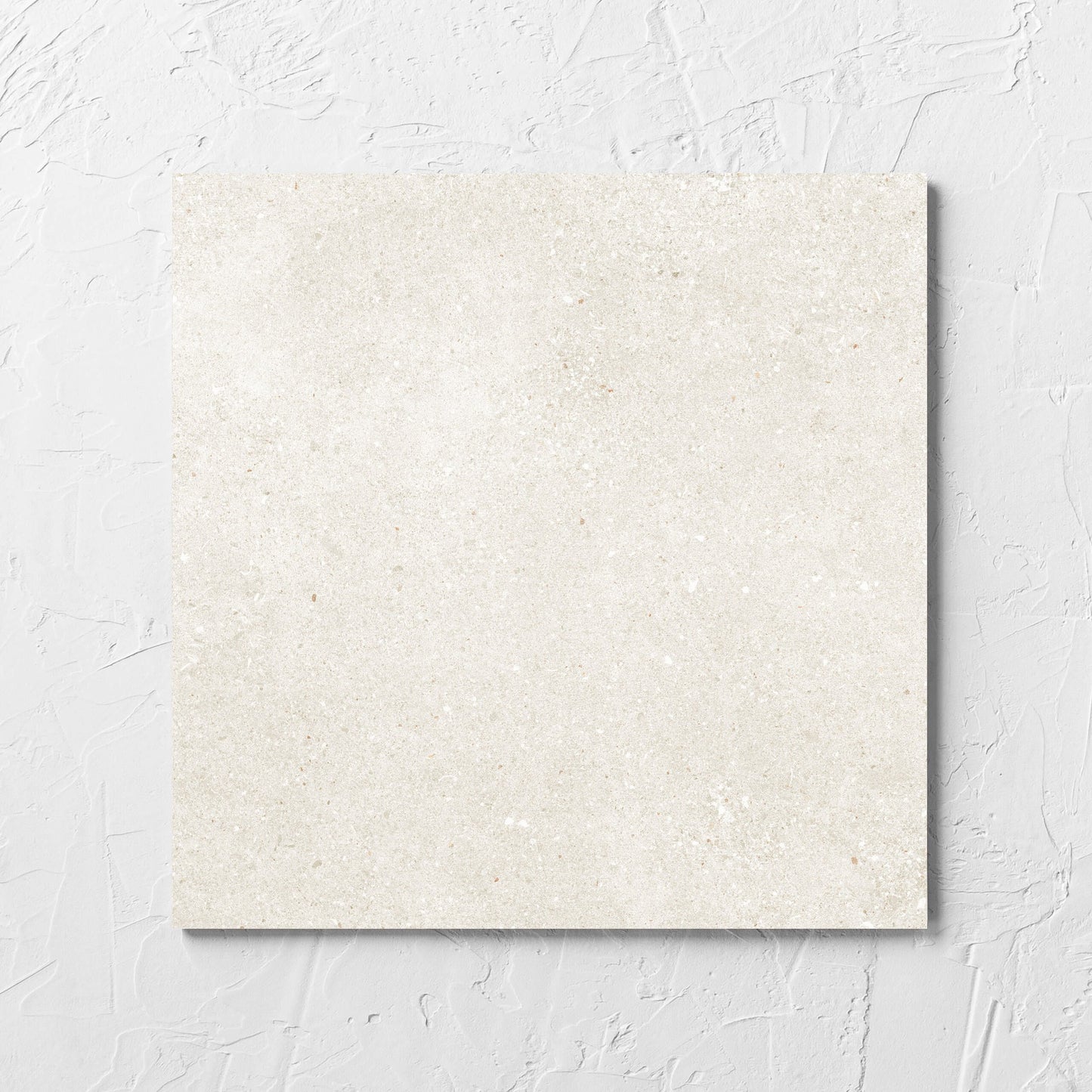Serenity Light Mocha 300x300mm tile laid flat on a white rendered wall, showing the matt surface