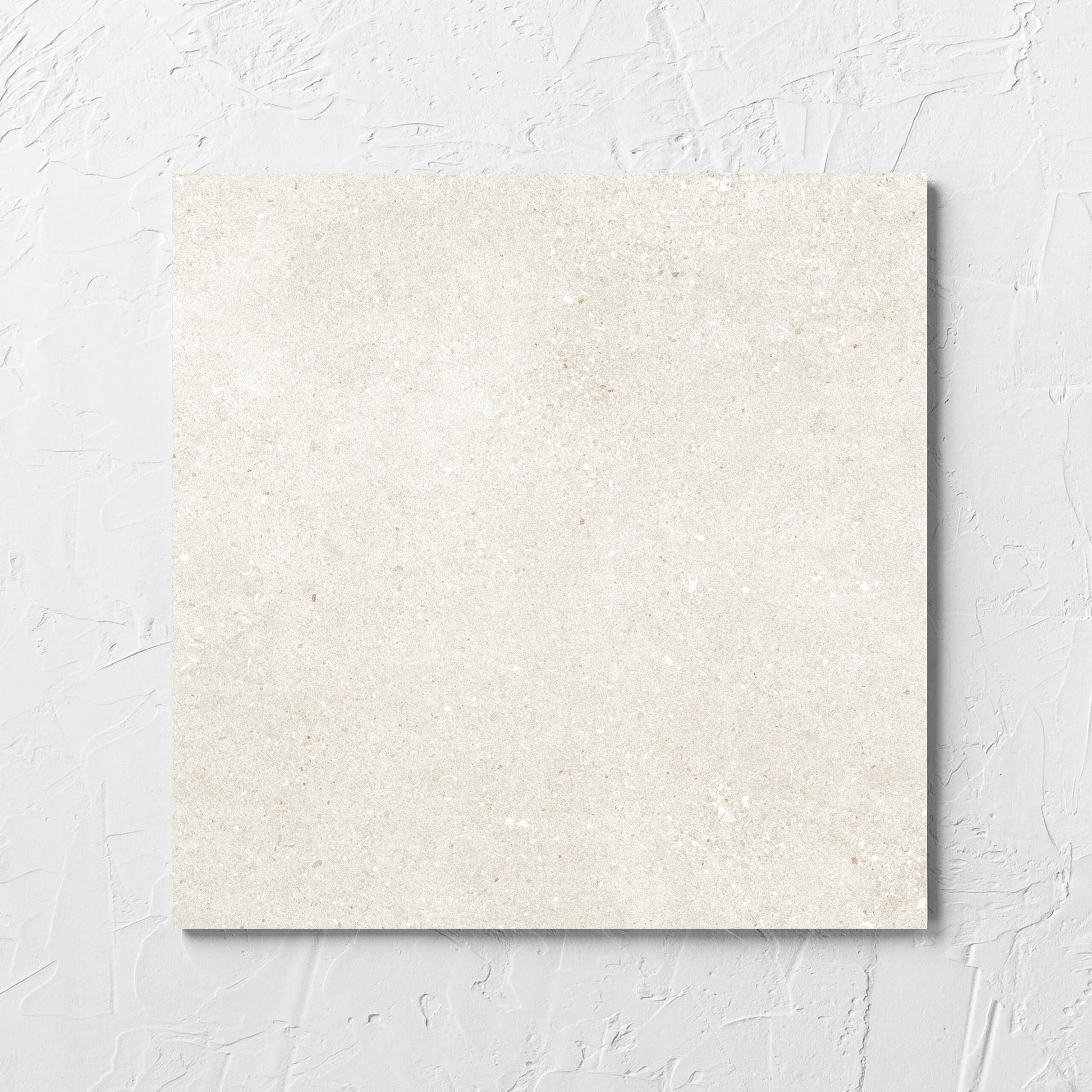 Serenity Light Mocha 300x300mm tile laid flat on a white rendered wall, showing the matt surface
