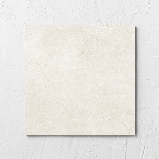 Serenity Light Mocha 300x300mm tile laid flat on a white rendered wall, showing the matt surface