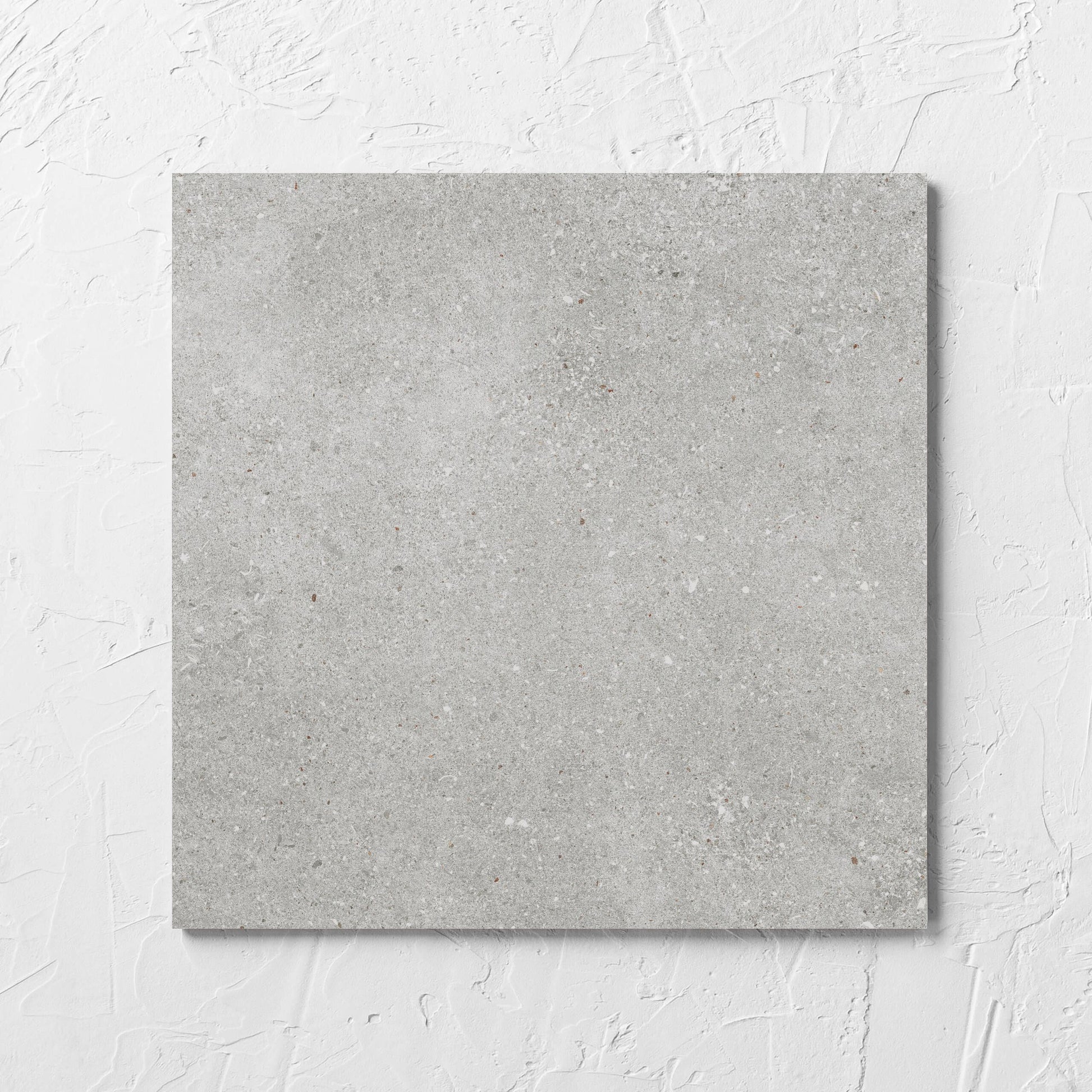 Serenity Urban Stone 300x300mm tile laid flat on a white rendered wall, showing the matt surface