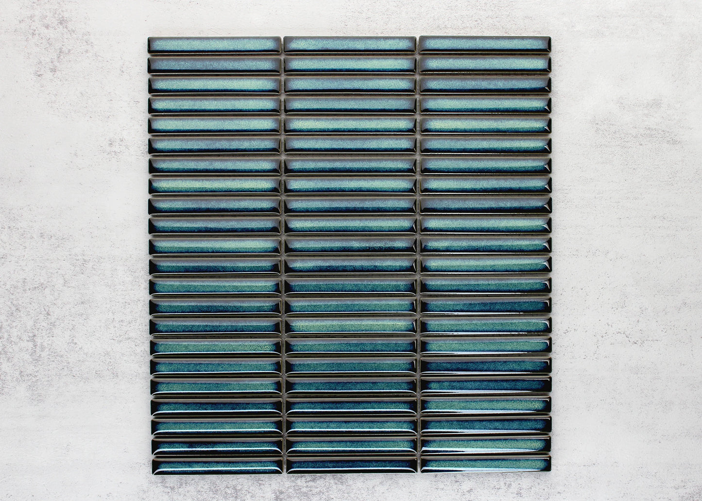 Flat lay pack shot of Shadow Dark Green Gloss Porcelain KitKat 12x92mm mosaic sheet showing elongated glossy teal-green finger tiles arranged in stacked rows.