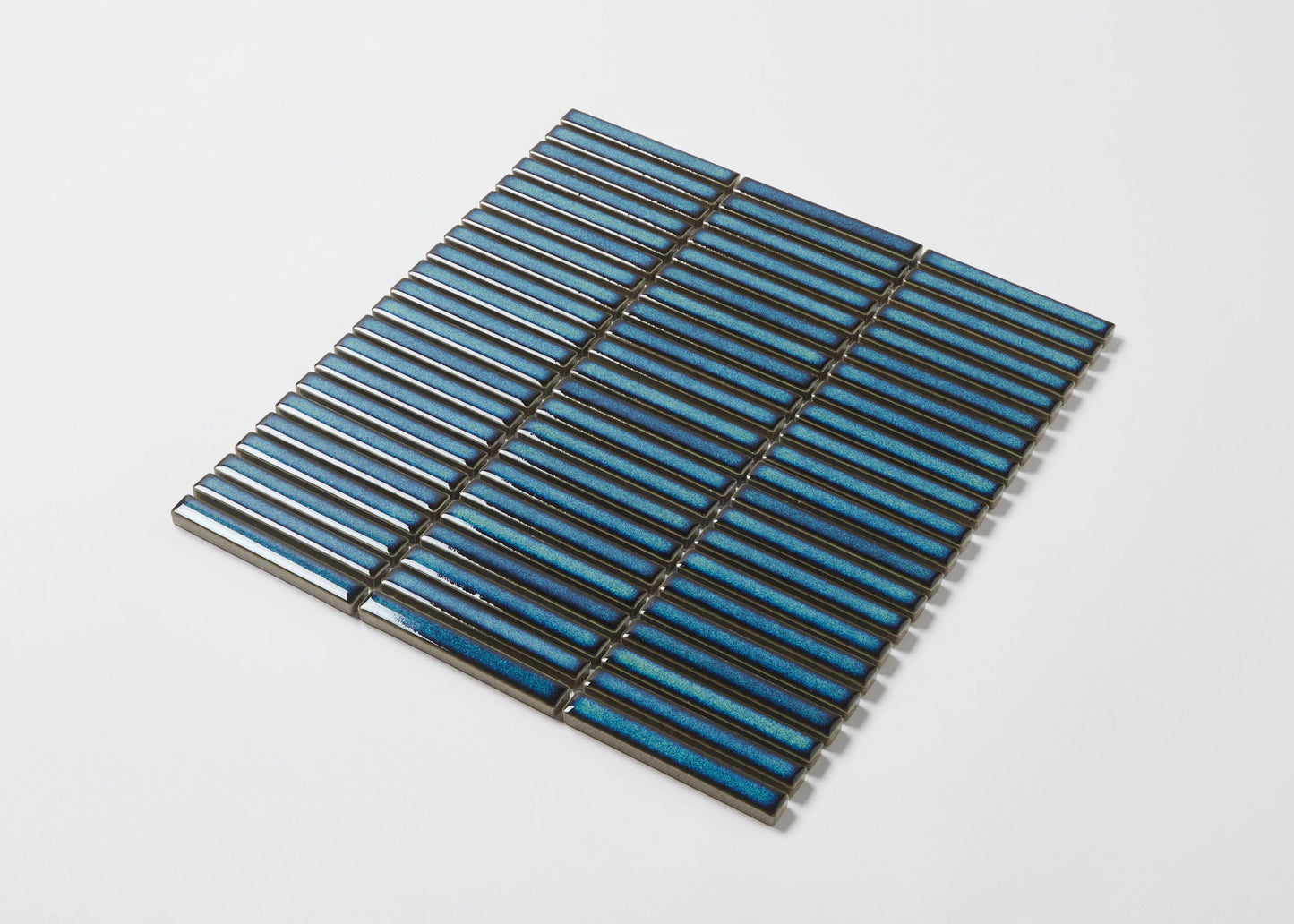 Pack shot of Shadow Dark Green Gloss Porcelain KitKat 12x92mm mosaic tile sheet showing iridescent teal-blue elongated finger tiles arranged in an offset stacked pattern.