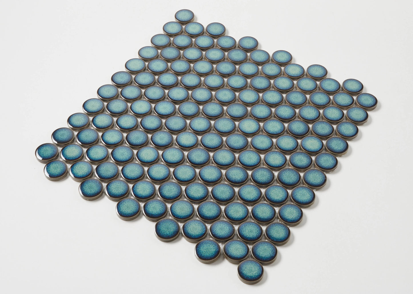 Pack shot of Shadow Green Gloss Glazed Porcelain Penny Round 28mm Diameter tiles arranged in a diamond pattern, showcasing their teal blue gloss finish and circular shape.