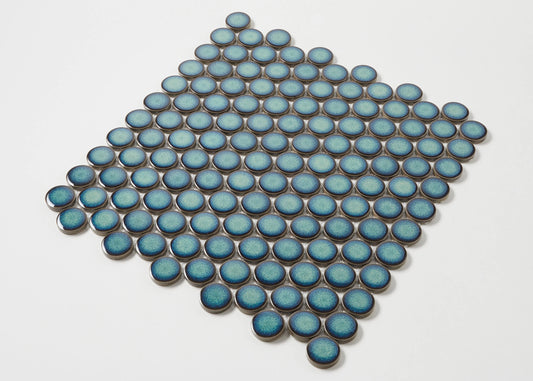 Pack shot of Shadow Green Gloss Glazed Porcelain Penny Round 28mm Diameter tiles arranged in a diamond pattern, showcasing their teal blue gloss finish and circular shape.