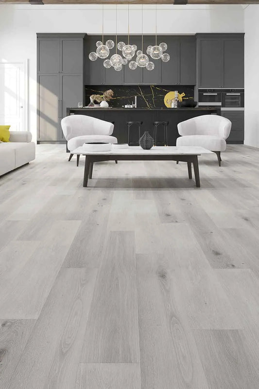 Snow Grey Elegant SPC Hybrid 9.5mm Flooring 7.5+2mm installed in a contemporary open-plan living area featuring white armchairs, marble coffee table, and dark grey kitchen cabinetry with globe pendant lights.