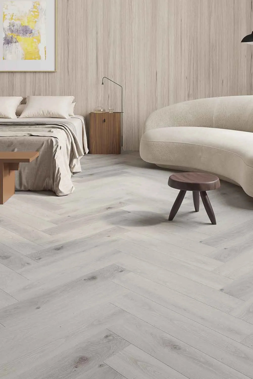 Snow Grey Elegant SPC Hybrid Herringbone 9.5mm Flooring 7.5+2mm installed in a modern bedroom with a curved sofa, wooden stool, and timber wall panelling.