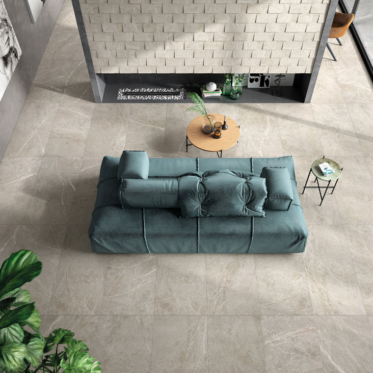 Soap Stone White External 600x600mm tiles installed as a living room floor beneath a teal sofa and round wooden coffee table.