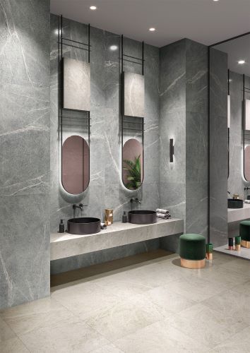 Soap Stone White External 600x600mm tiles installed as floor and feature wall in a luxury bathroom with double vessel sinks and oval mirrors.