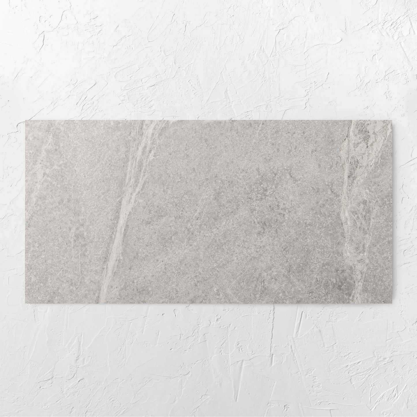 Soap Stone White Honed 600x1200mm tile laid flat on a white rendered wall, showing the tile surface