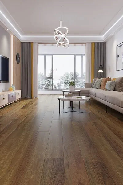 Spotted Gum Urban Laminate 12mm Flooring 12mm installed in a modern living room with a sectional sofa, round coffee table, and large window.