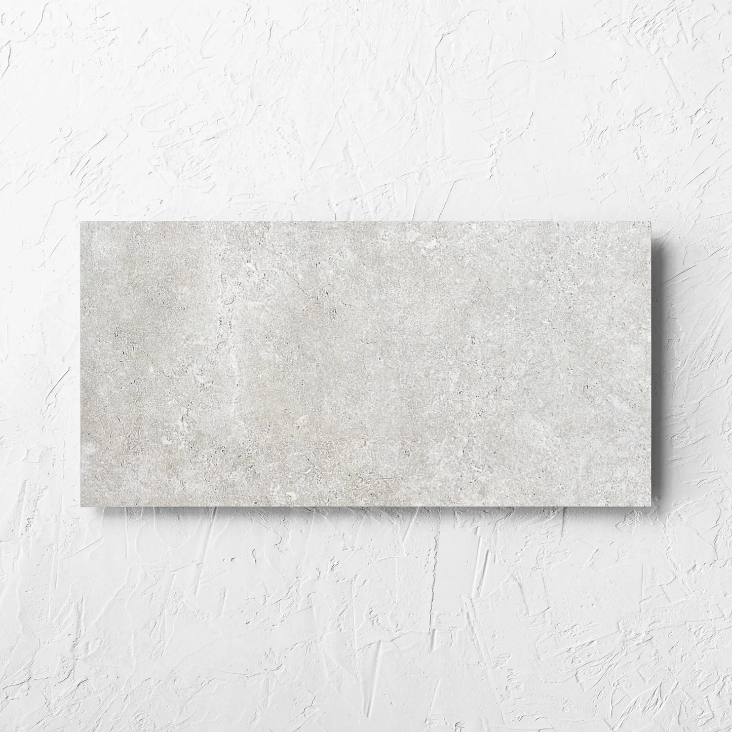 Stella Ash Matt 300x600mm tile laid flat on a white rendered wall, showing the tile surface