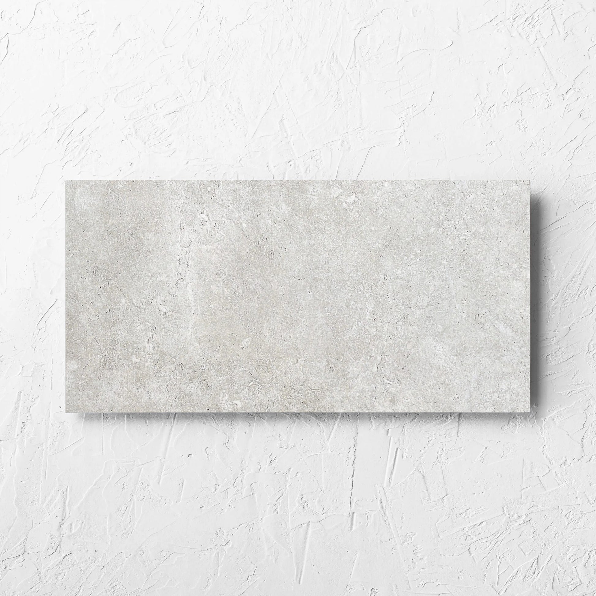 Stella Ash Matt 300x600mm tile laid flat on a white rendered wall, showing the tile surface