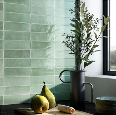 T-Brick Eucalyptus Gloss Subway 52x160mm tiles installed on a kitchen wall styled with pears, a dark metal vase, and leafy branches.