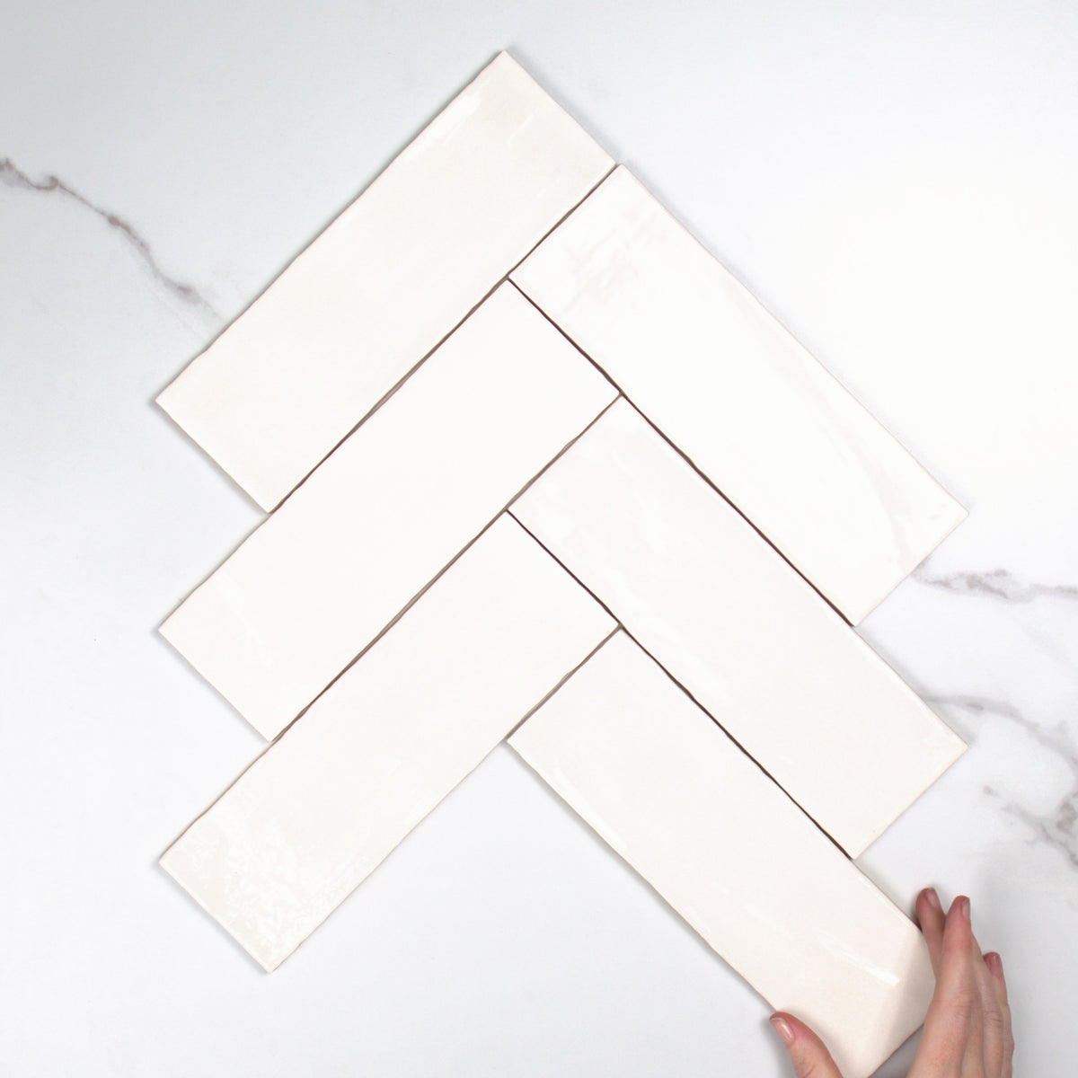 Tabarca Blanco Gloss 75x230mm top view, hand for scale