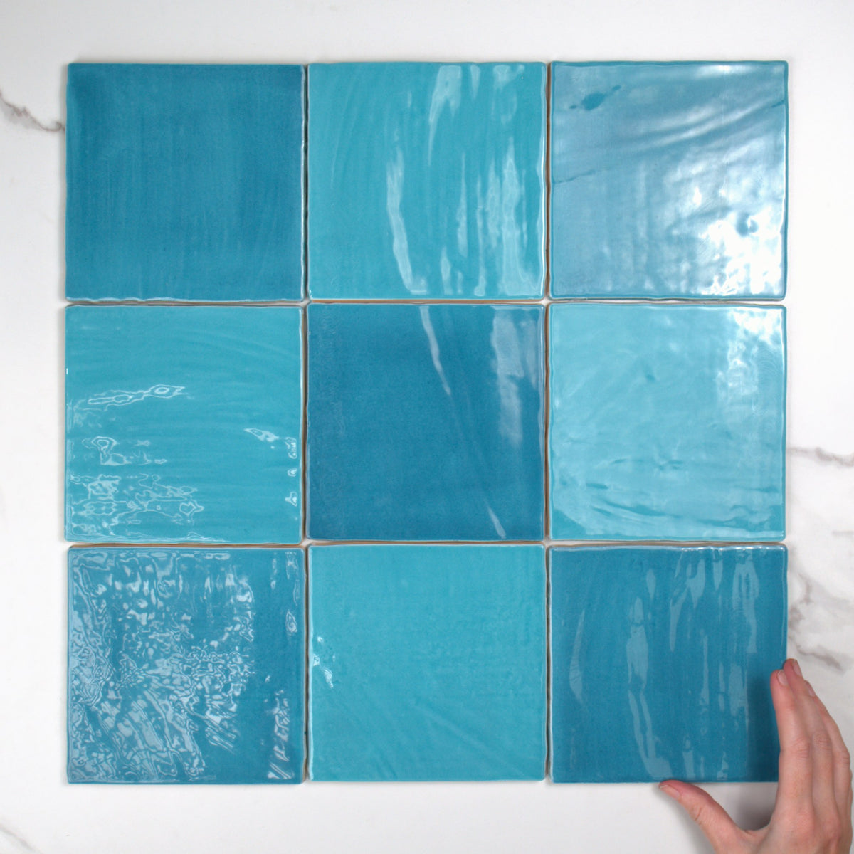 Tabarca Cielo Gloss 150x150mm top view, hand for scale