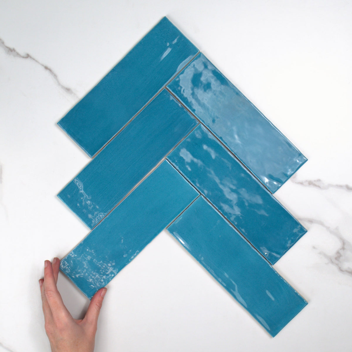 Tabarca Cielo Gloss 75x230mm top view, hand for scale
