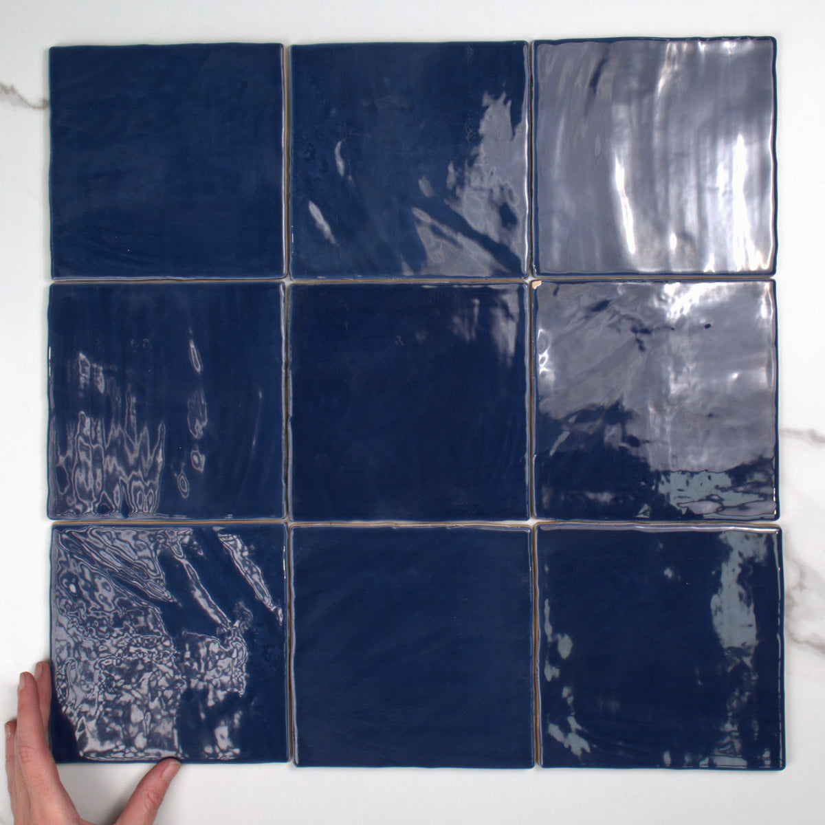 Tabarca Marino Gloss 150x150mm top view, hand for scale