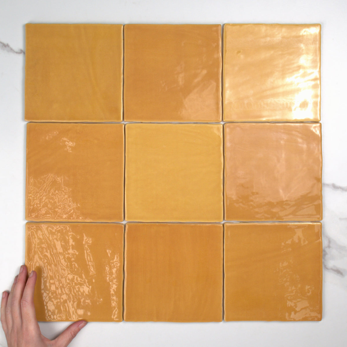 Tabarca Miel Gloss 150x150mm top view, hand for scale