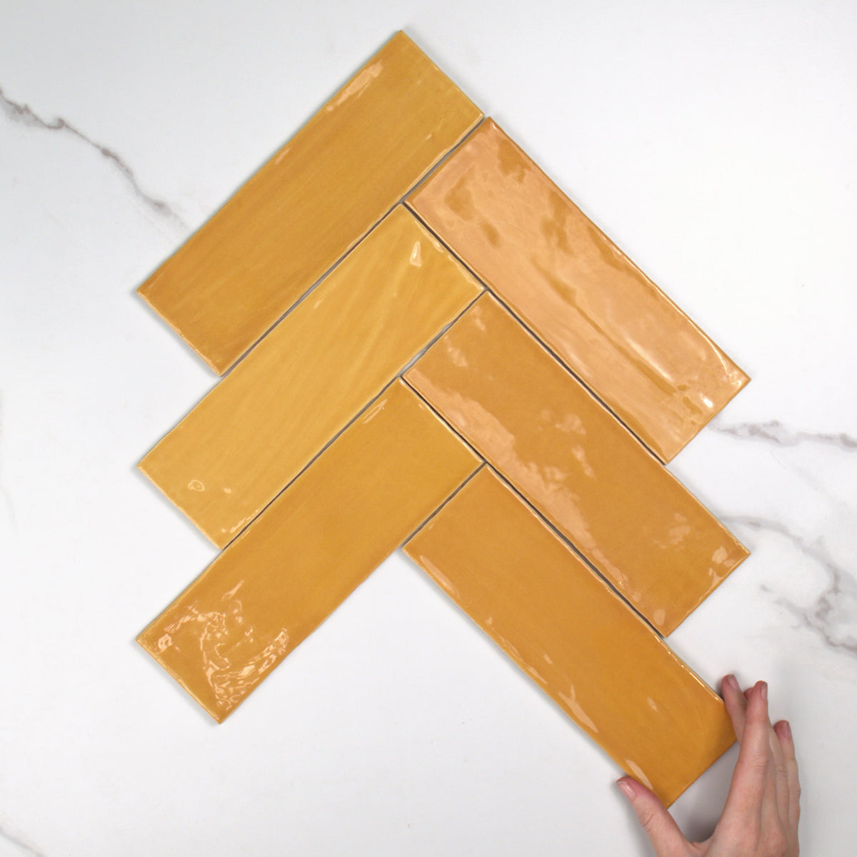 Tabarca Miel Gloss 75x230mm top view, hand for scale