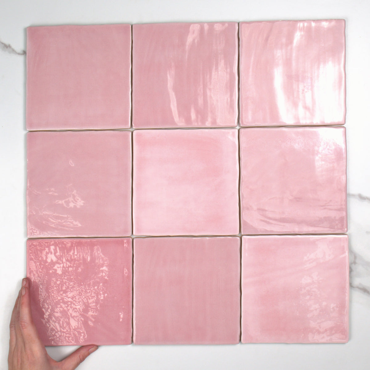 Tabarca Rosa Gloss 150x150mm top view, hand for scale