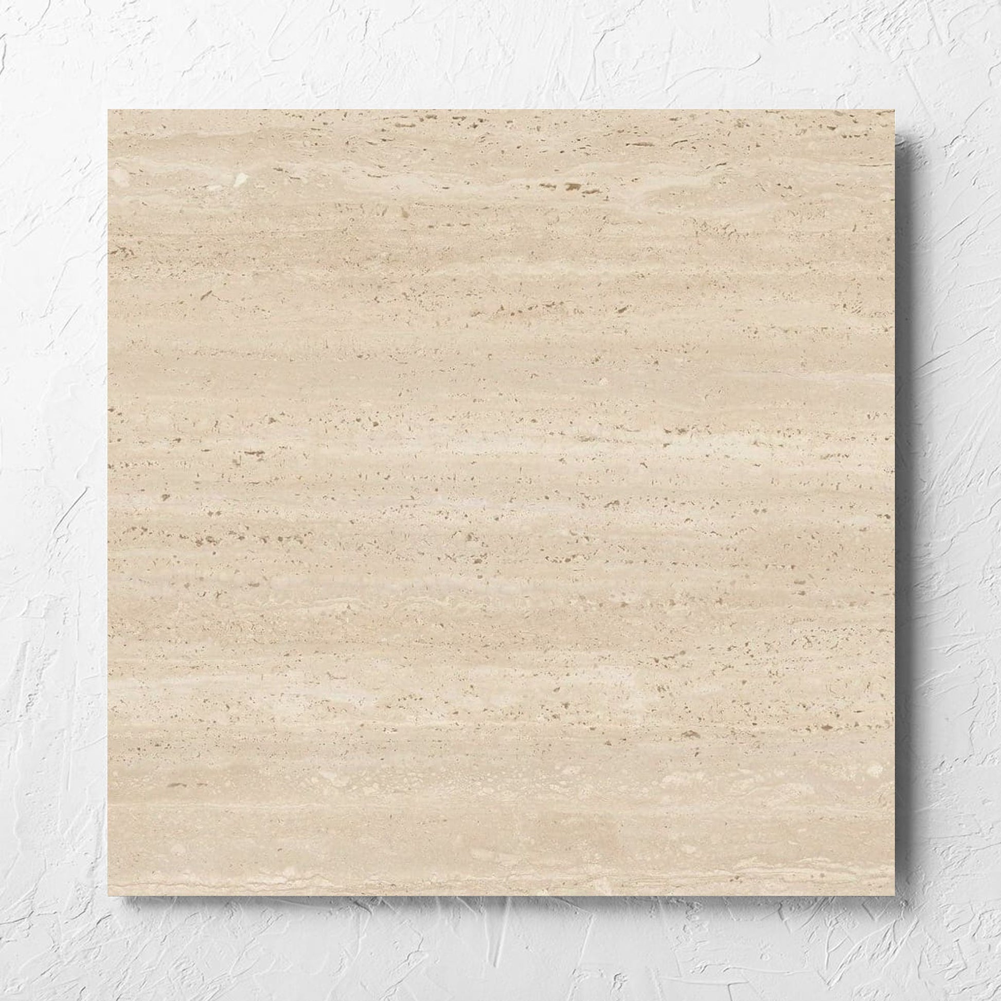 Tallow Vein Cut Travertine Look Beige 600x600mm tile laid flat on a white rendered wall, showing the beige matt surface