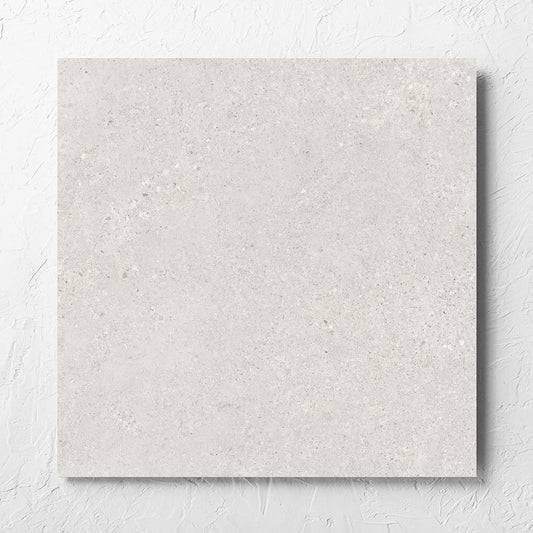 Terramix Cream Lappato 600x600mm tile laid flat on a white rendered wall, showing the matt surface