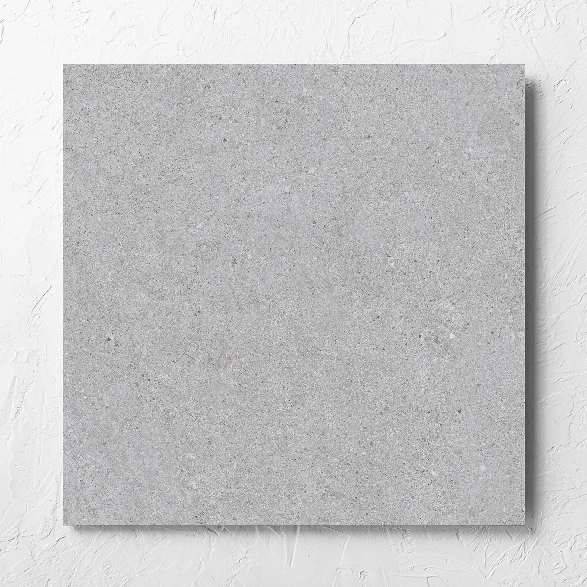 Terramix Silver Matt 600x600mm tile laid flat on a white rendered wall, showing the matt surface