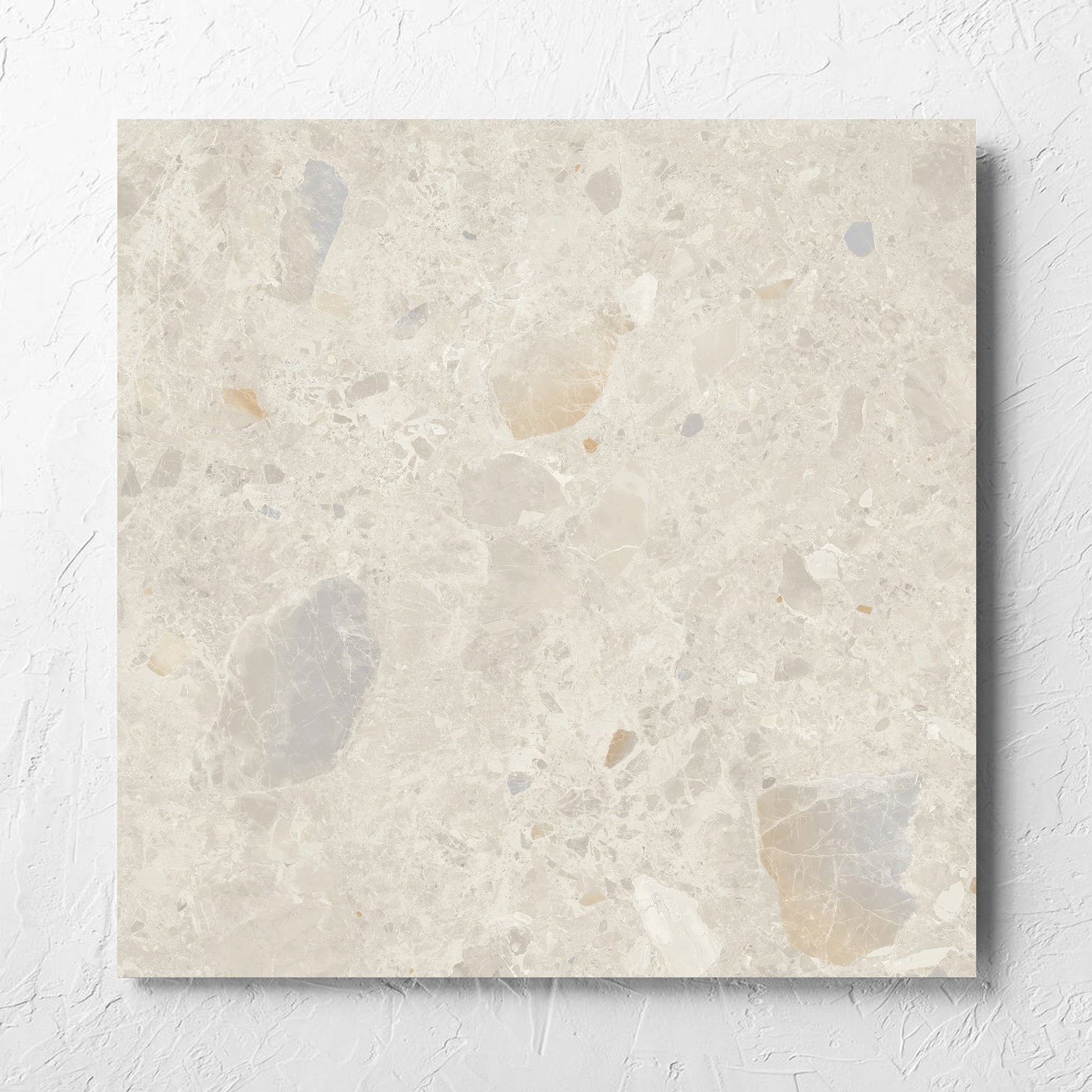 Terrazzo Rock Beige Matt 600x600mm tile laid flat on a white rendered wall, showing the tile surface