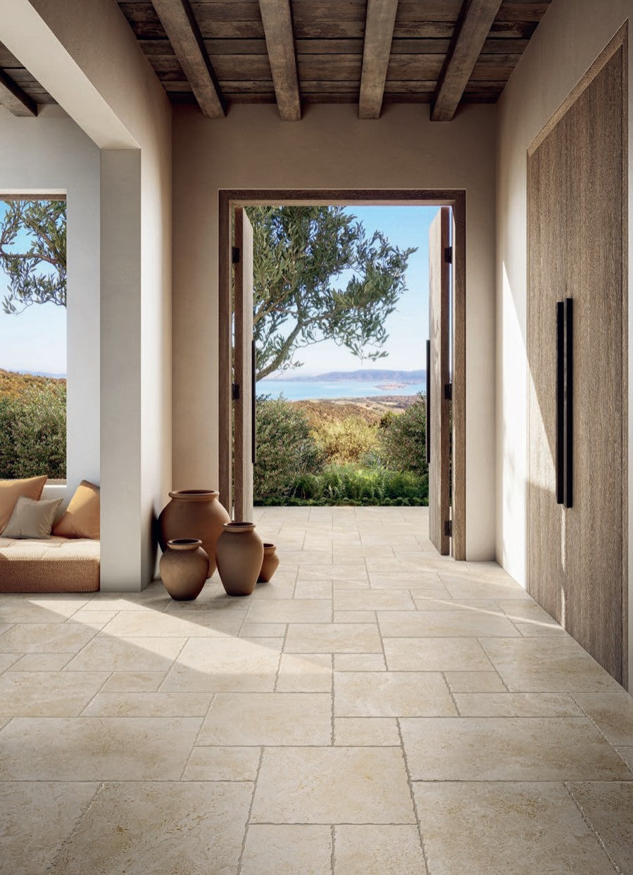 Tibur Beige Safe Modulo French Pattern 400x600mm tiles installed in a sunlit Mediterranean hallway with rustic timber ceiling beams, terracotta pots, and sweeping landscape views.