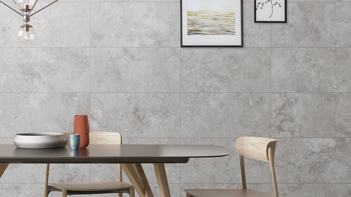 Timeless Silver Structured 600x600mm grey stone-effect wall tiles installed in a modern dining room with wooden furniture and pendant light.