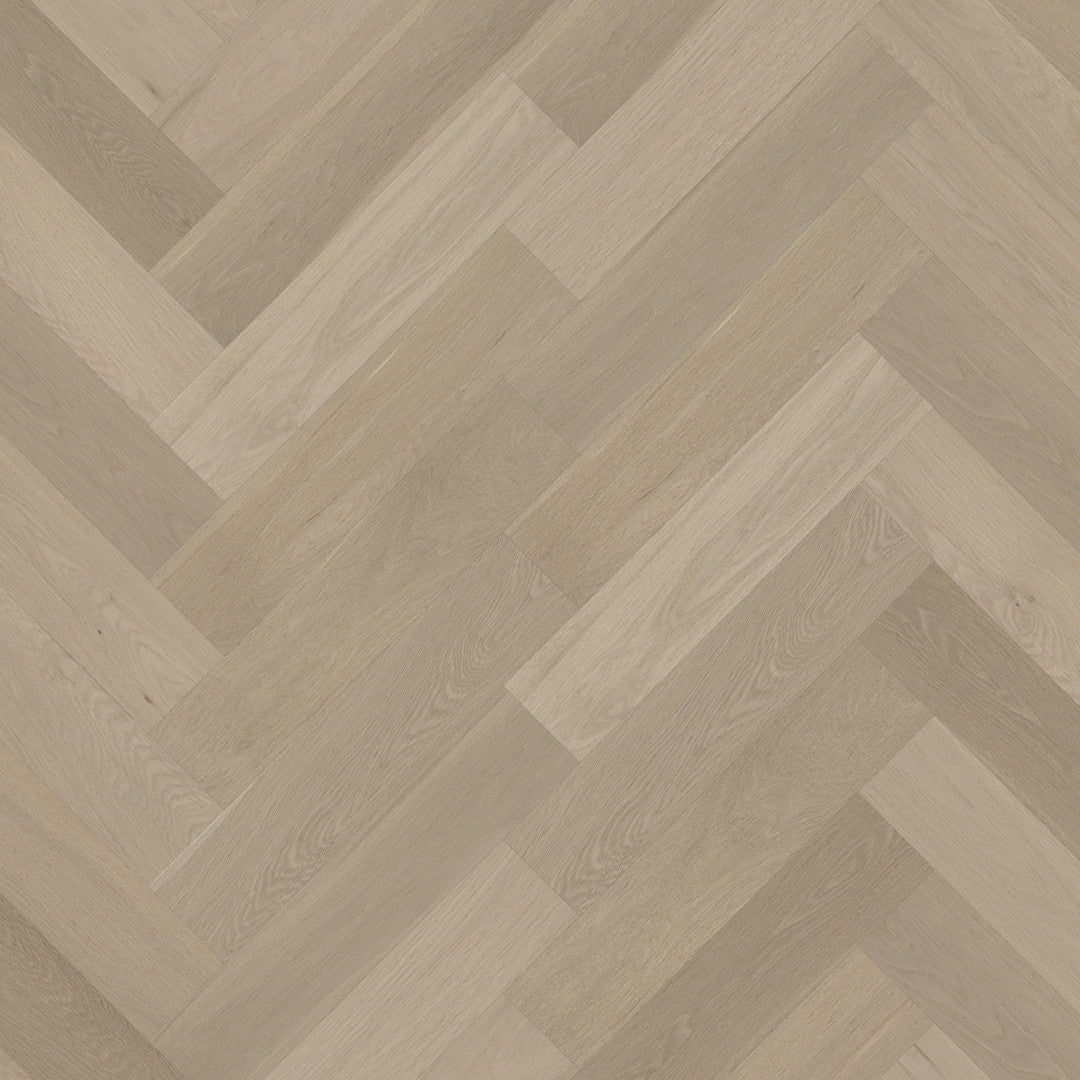 Close-up of Tinge Clay iDesign Herringbone Flooring 15/3mm showing a warm grey-beige oak wood surface laid in a classic diagonal herringbone pattern.
