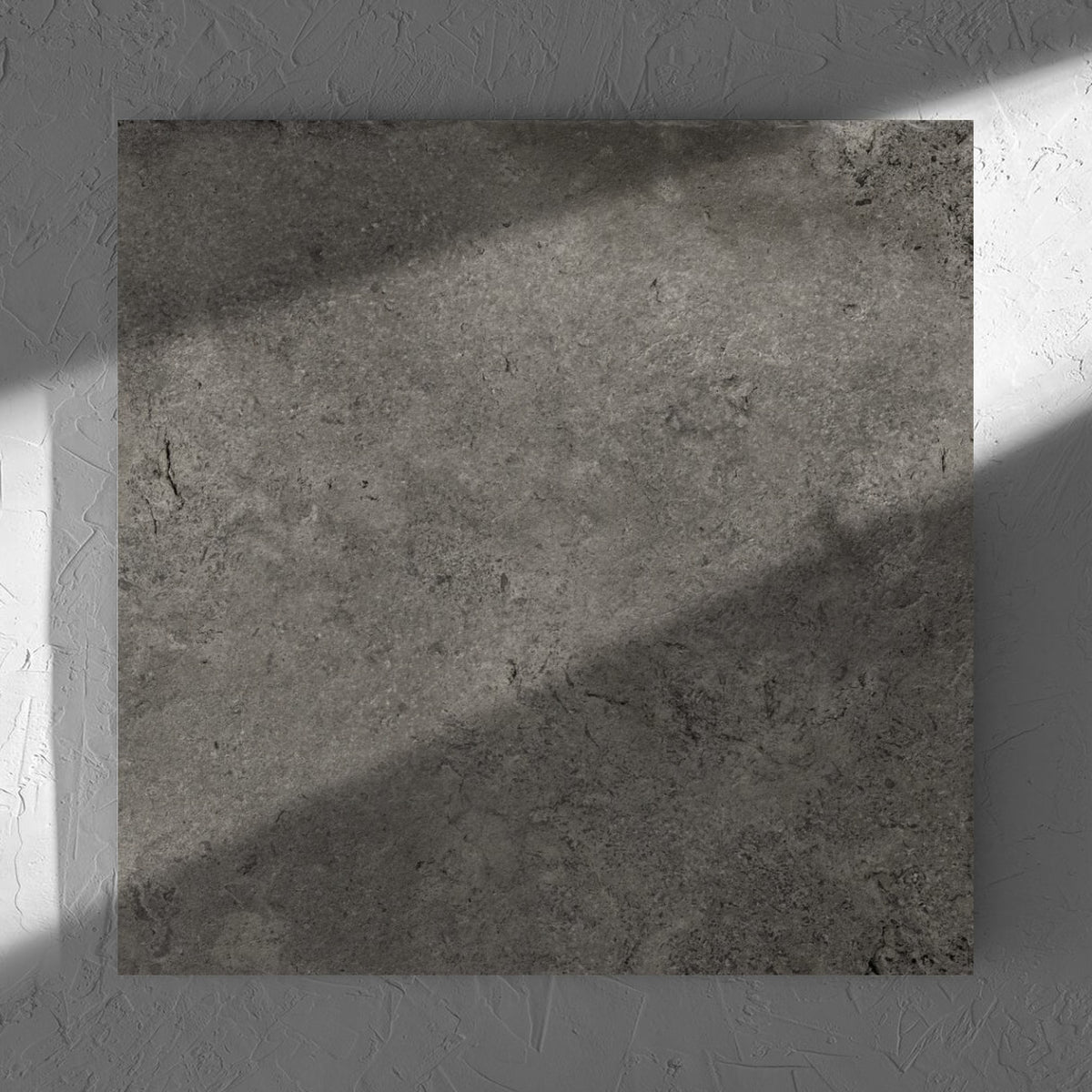 Toulouse Dark Grey Amber 600x600mm tile in soft natural window light, showing the matt surface