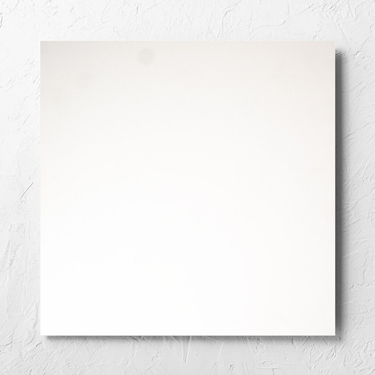 Unicolour Super White Matt 600x600mm tile laid flat on a white rendered wall, showing the super white matt surface