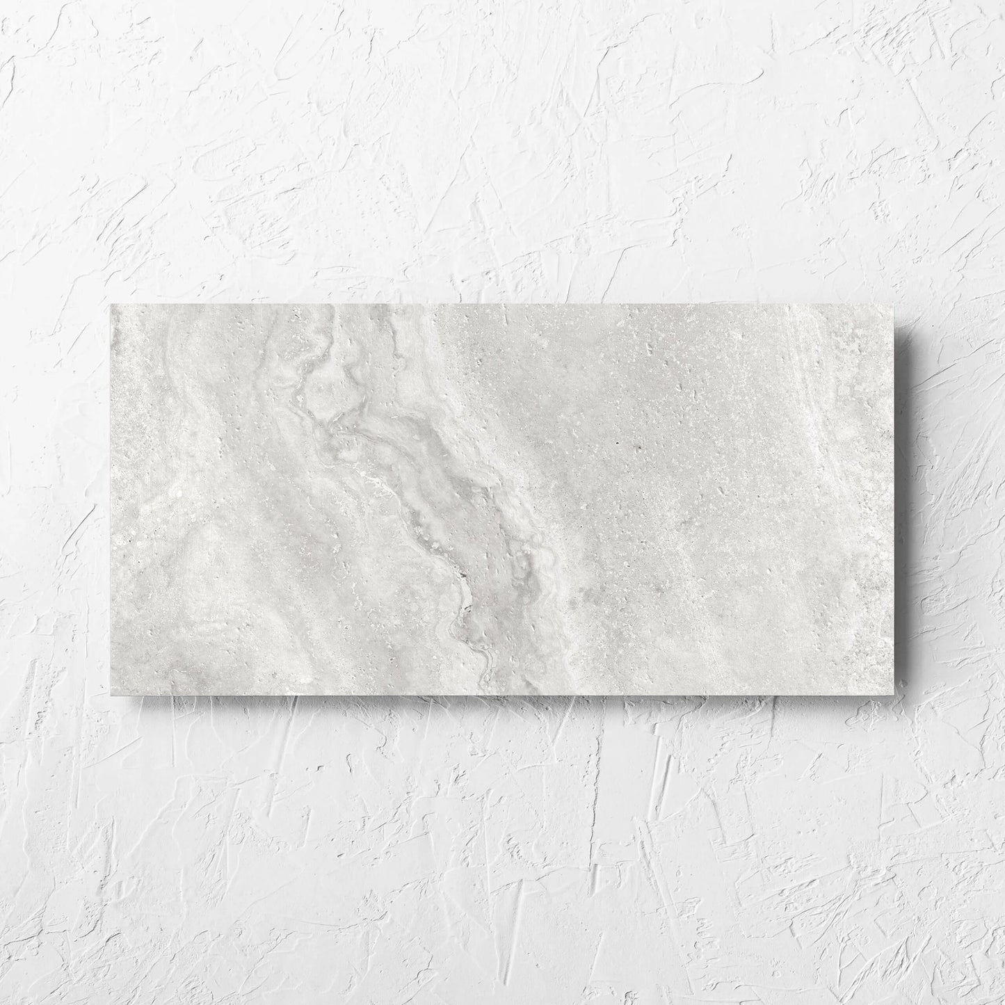 Vatican Silver Cross Cut Travertine 300x600mm tile laid flat on a white rendered wall, showing the matt surface
