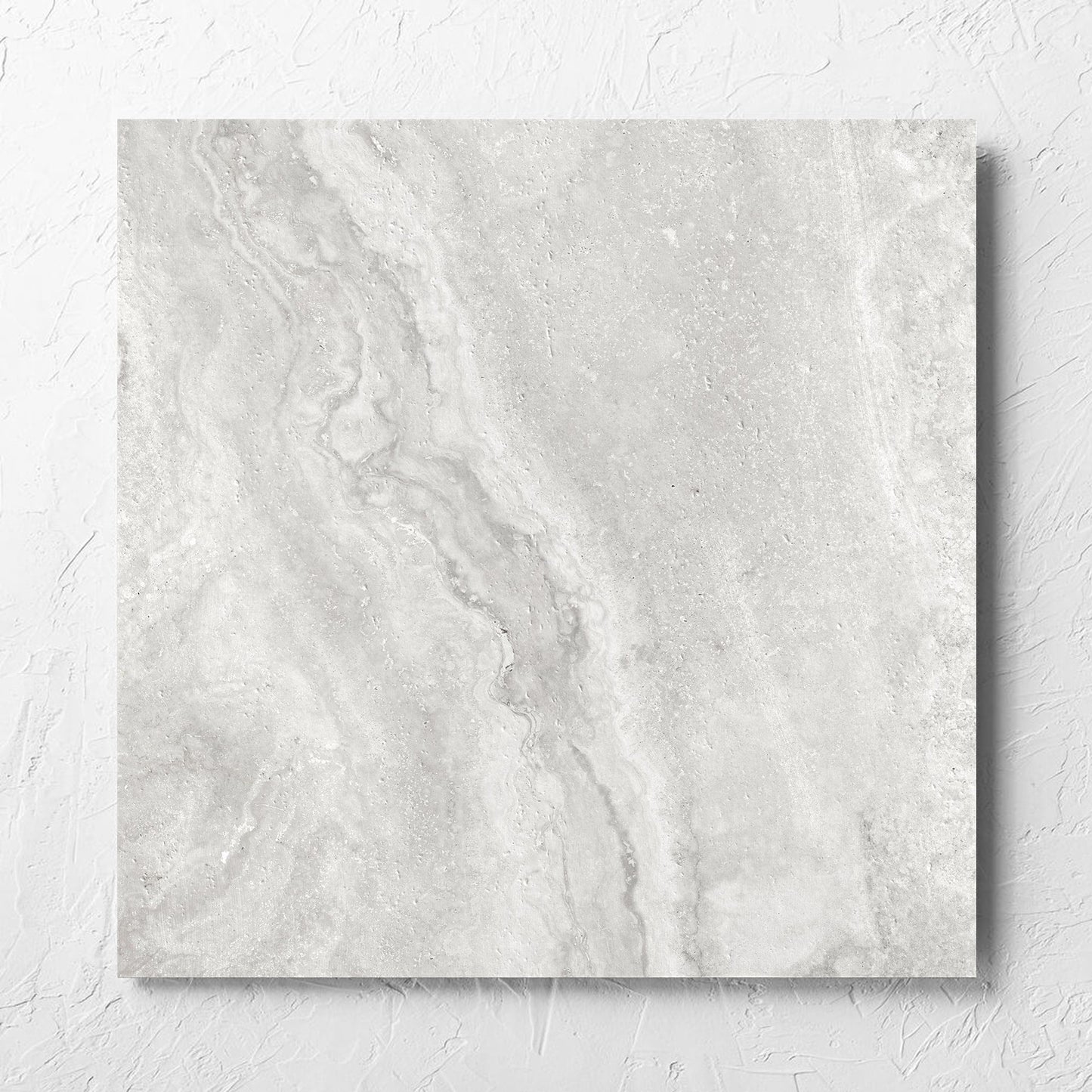 Vatican Silver Vein Cut Travertine 600x600mm tile laid flat on a white rendered wall, showing the matt surface