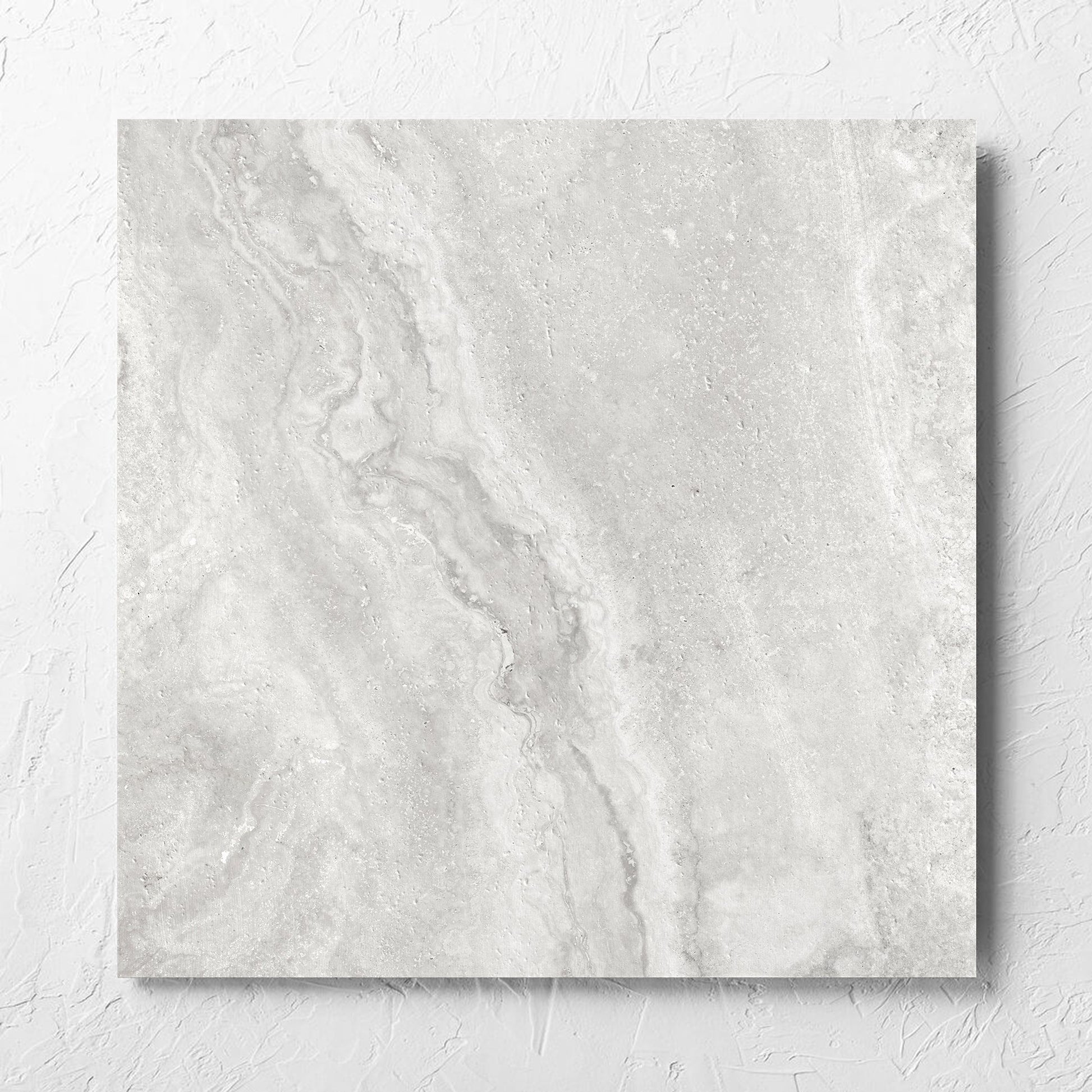 Vatican Silver Vein Cut Travertine 600x600mm tile laid flat on a white rendered wall, showing the matt surface