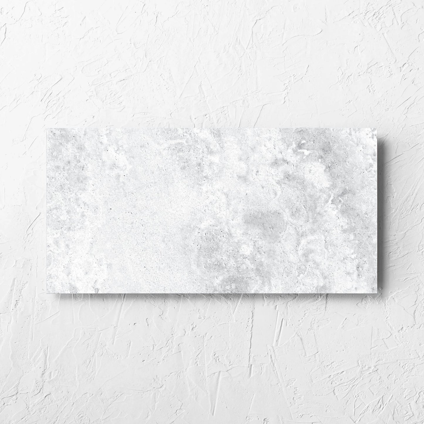 Vatican White Cross Cut Travertine 300x600mm tile laid flat on a white rendered wall, showing the matt surface