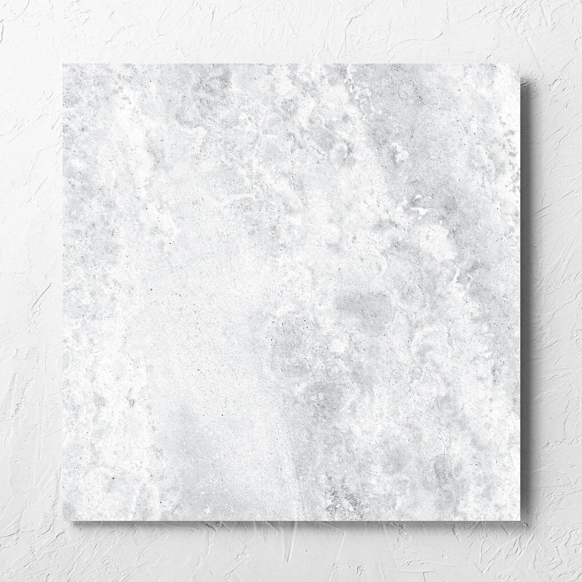 Vatican White Cross Cut Travertine 600x600mm tile laid flat on a white rendered wall, showing the matt surface