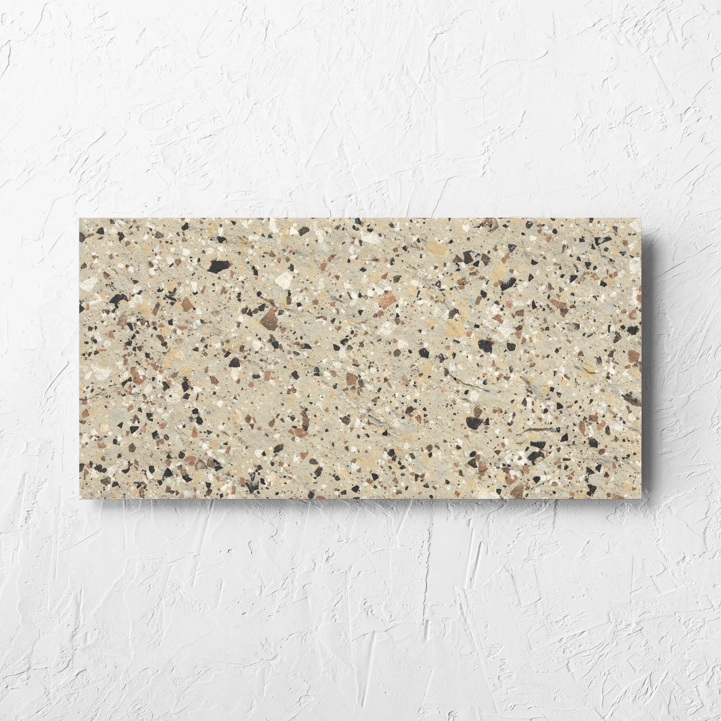 Venice Beige 300x600mm Matt Terrazzo External Tile laid flat on a white rendered wall, showing the beige matt surface