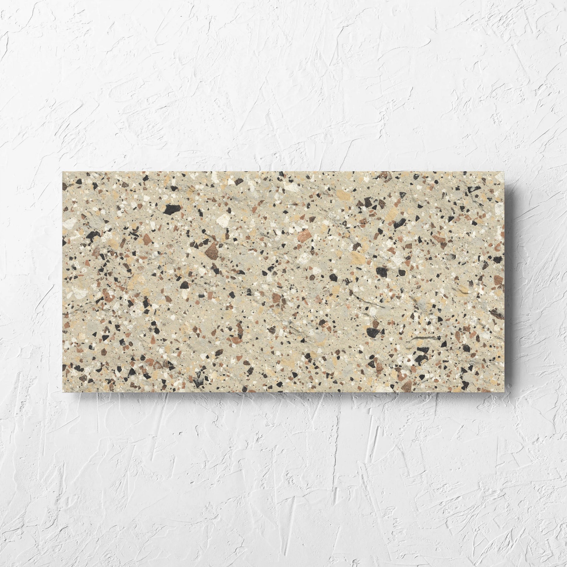 Venice Beige 300x600mm Matt Terrazzo External Tile laid flat on a white rendered wall, showing the beige matt surface