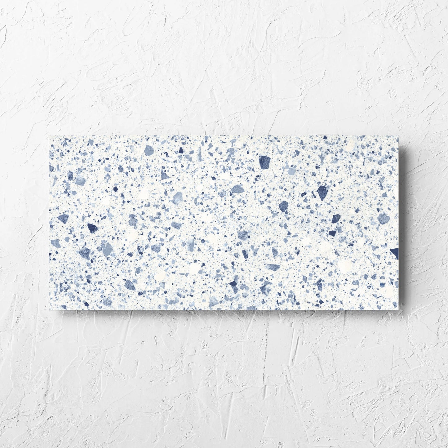 Venice Blue 300x600mm Matt Terrazzo Tile laid flat on a white rendered wall, showing the blue matt surface