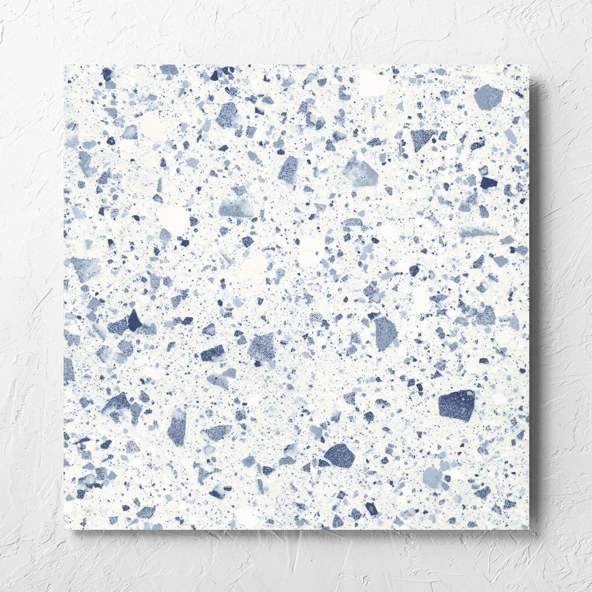 Venice Blue 600x600mm Matt Terrazzo Tile laid flat on a white rendered wall, showing the blue matt surface