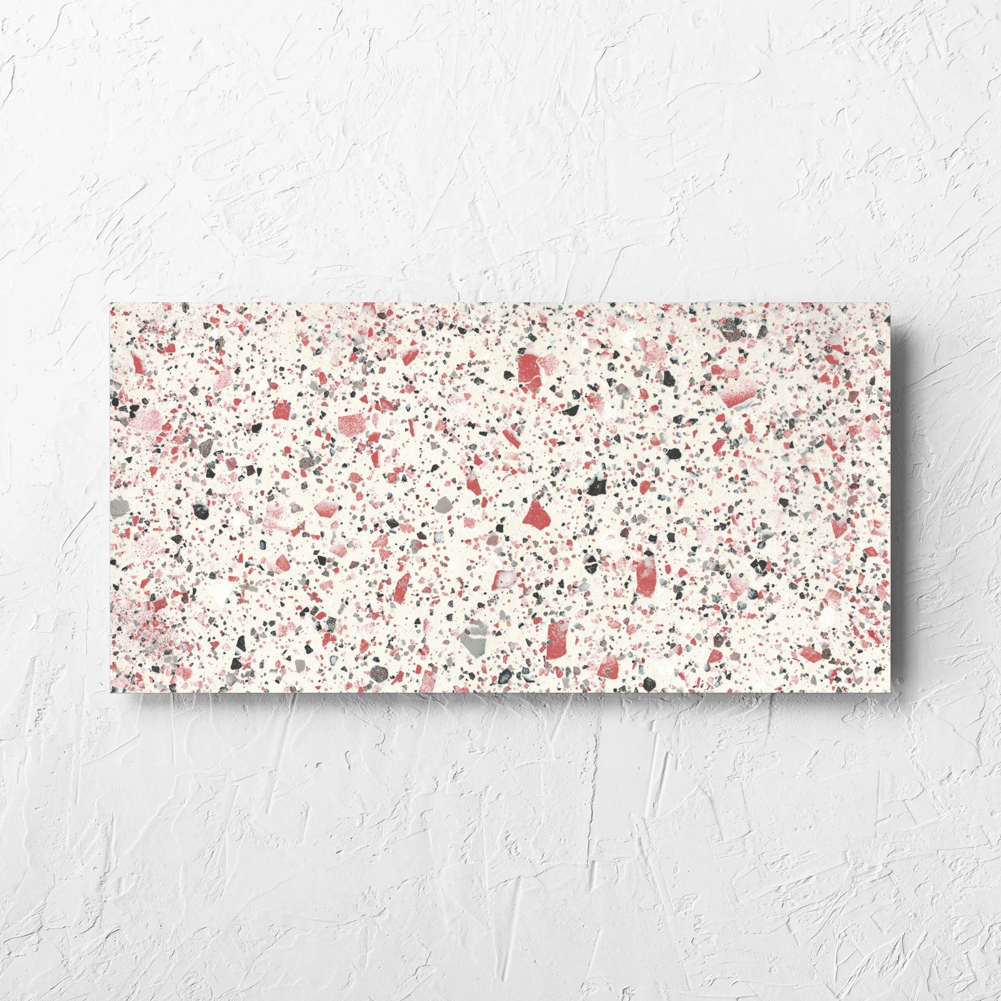 Venice Coral 300x600mm Matt Terrazzo Tile laid flat on a white rendered wall, showing the coral matt surface