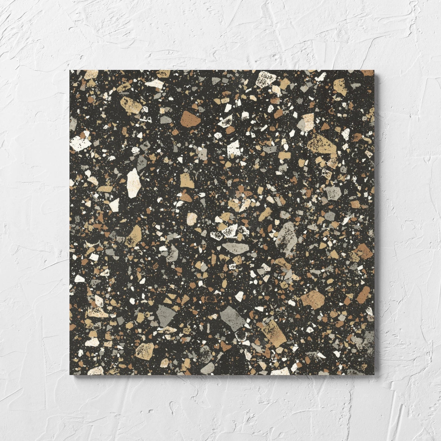 Venice Earth 300x300mm Matt Terrazzo Tile laid flat on a white rendered wall, showing the earth matt surface