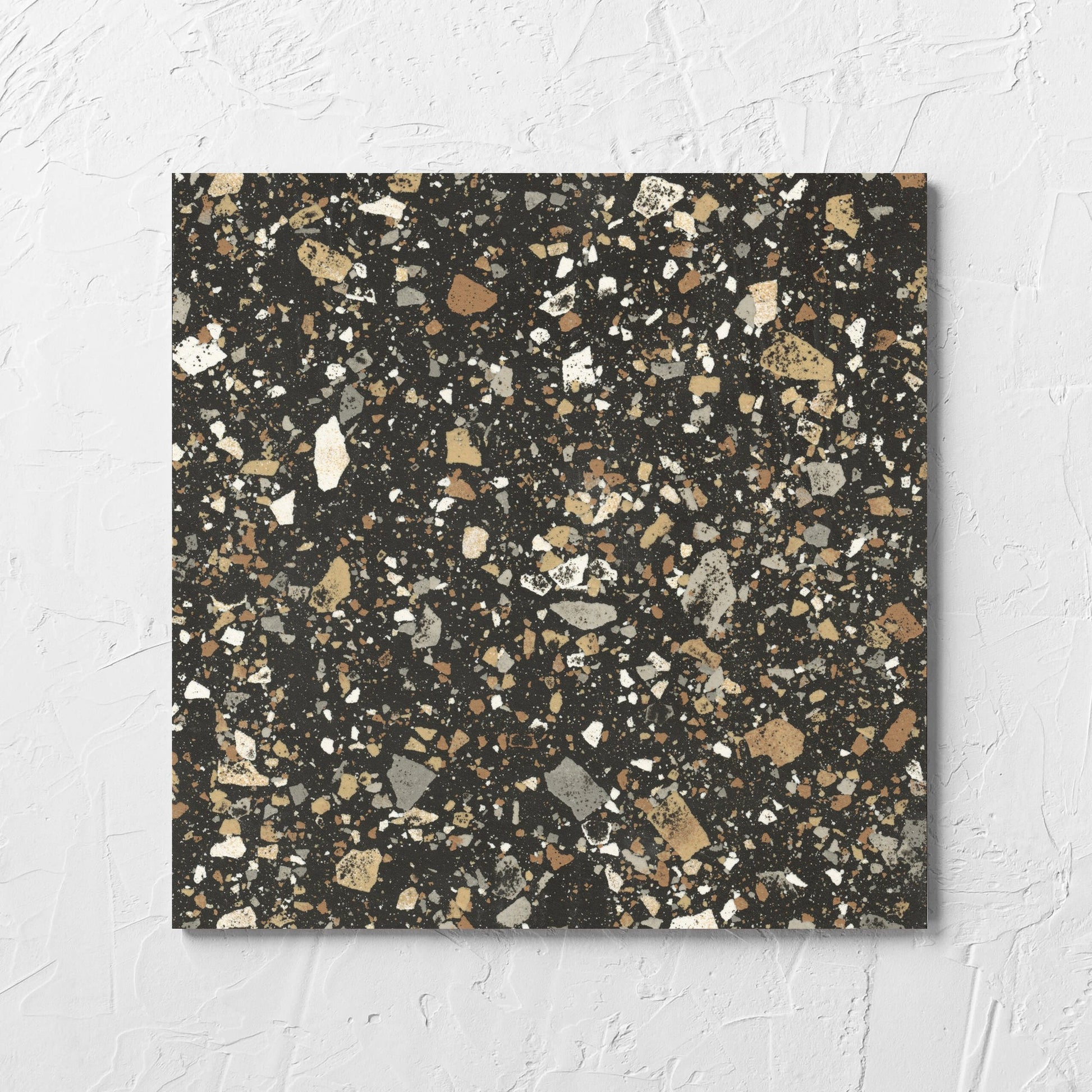 Venice Earth 300x300mm Matt Terrazzo Tile laid flat on a white rendered wall, showing the earth matt surface