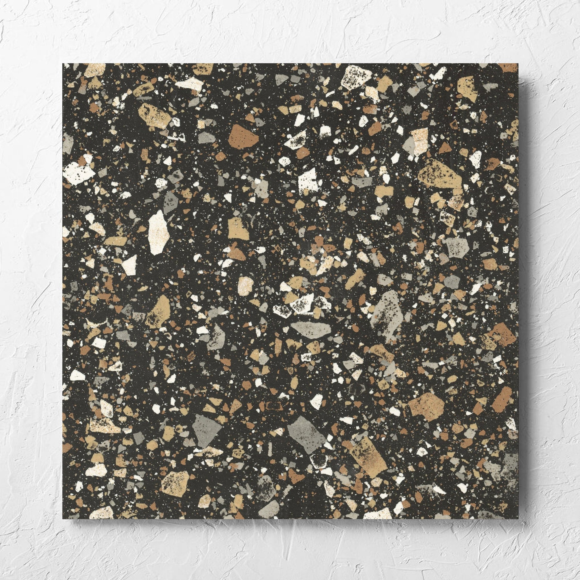 Venice Earth 600x600mm Matt Terrazzo Tile laid flat on a white rendered wall, showing the earth matt surface