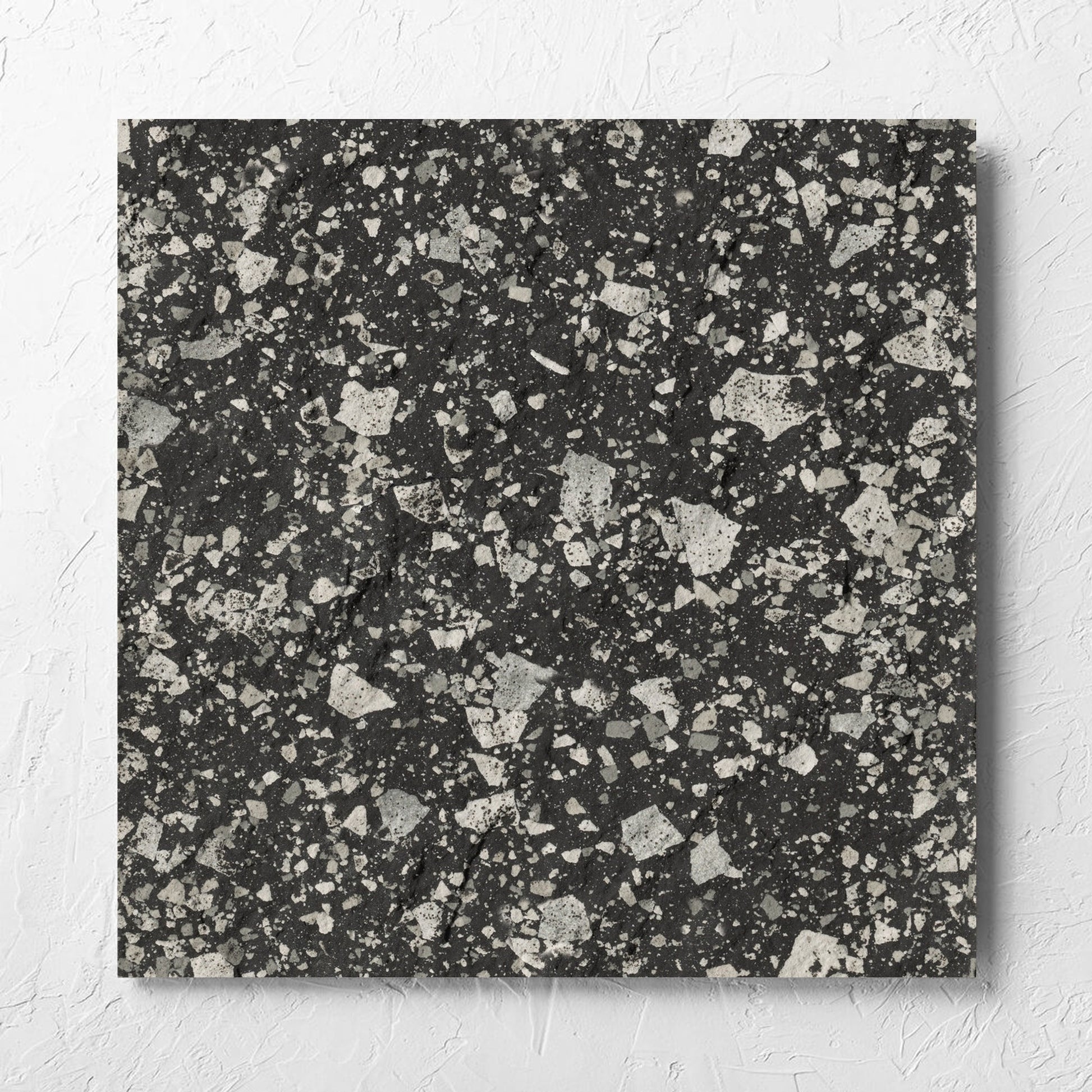 Venice Graphite 600x600mm Matt Terrazzo External Tile laid flat on a white rendered wall, showing the graphite matt surface
