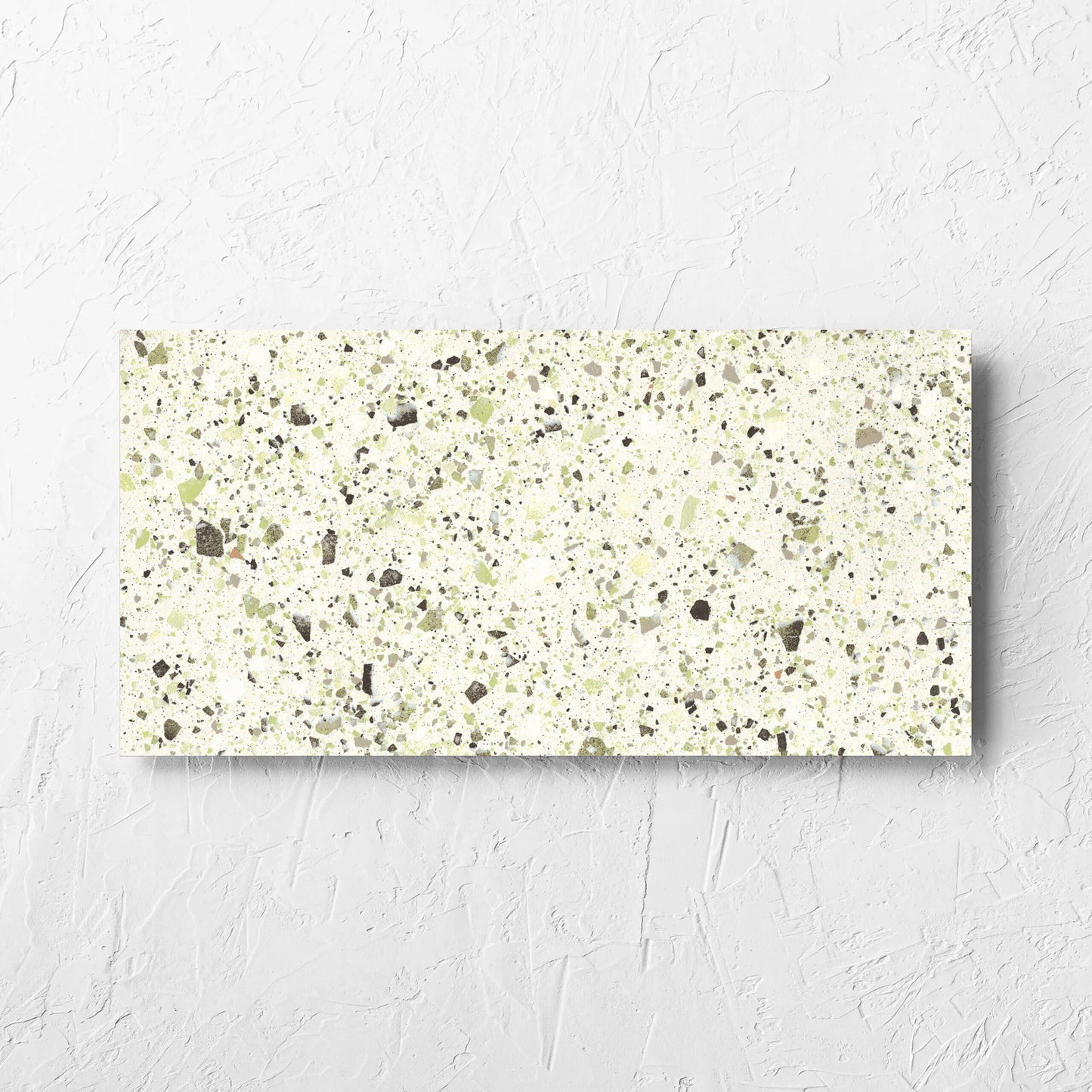 Venice Green 300x600mm Matt Terrazzo Tile laid flat on a white rendered wall, showing the green matt surface